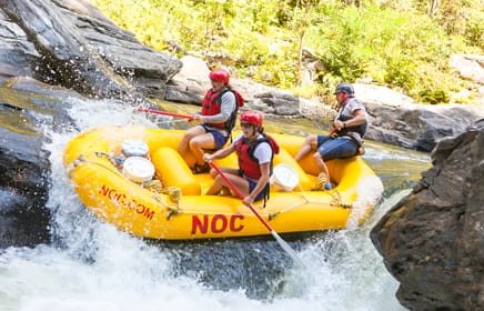 Yellow raft going over rapids on the Chattooga River Rafting: Section IV (with Lunch) trip