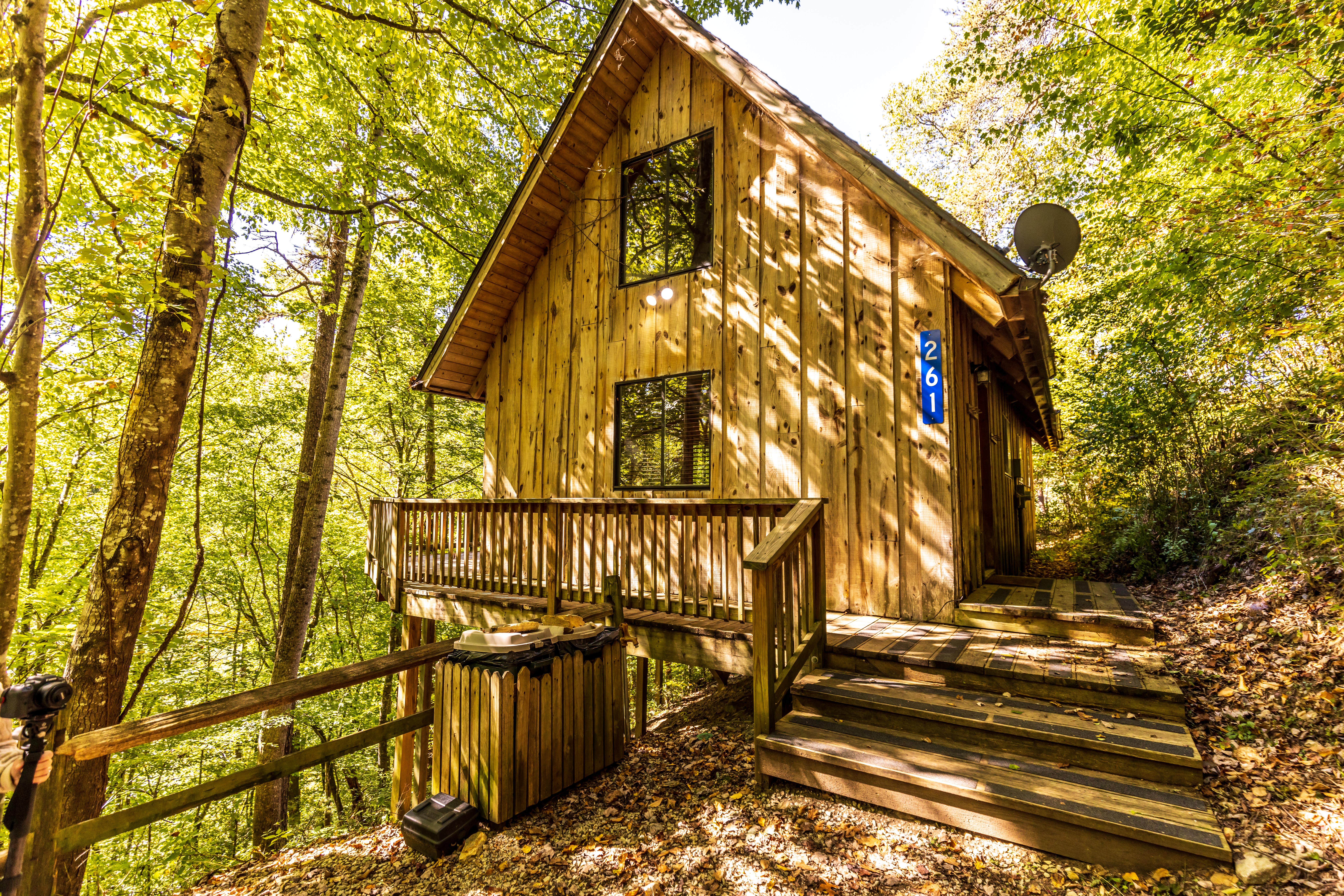 outside of wooden cabin with walkway railing and trees