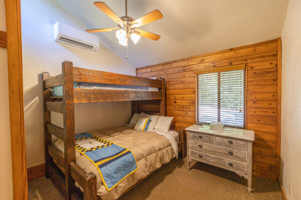 cabin bedroom with lower queen sized bed and upper twin bed