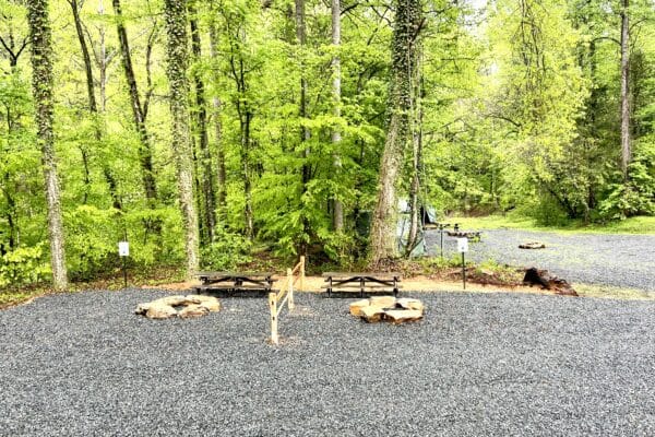 gravel area with picnic table, rock fire put, and fencing