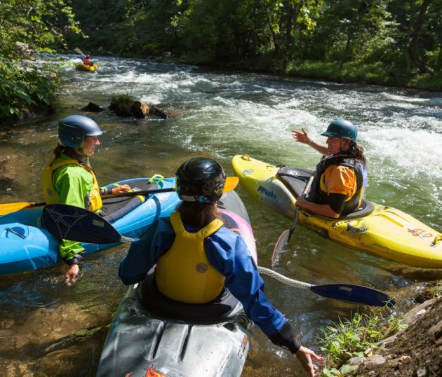 Three kayakers discussing route during the 5-Day Whitewater Kayaking/Canoeing Course