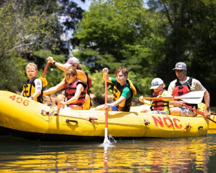 Family paddling a raft on the chattahoochee river