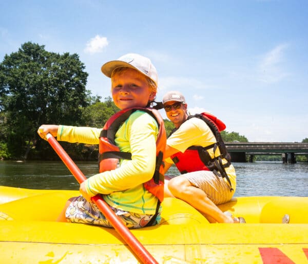 child and father paddling a raft on the chattahoochee