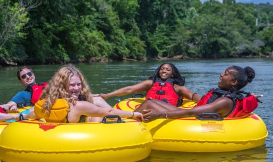 Young adults relaxing on tubes on the Chattahoochee River Tubing – Roswell trip