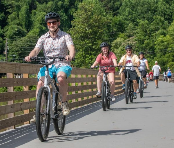 Guests biking on a bridge on the Chattahoochee River Bike Rentals – Roswell trip