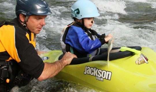 Instructor helping a child learn to kayak on the Private Canoe and Kayak Instruction course