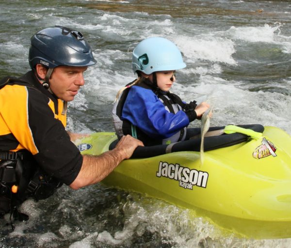 Instructor helping a child learn to kayak on the Private Canoe and Kayak Instruction course