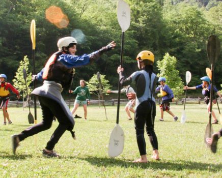 staff and campers playing lawn games at kayaking camp