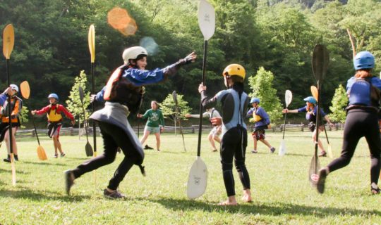 staff and campers playing lawn games at kayaking camp