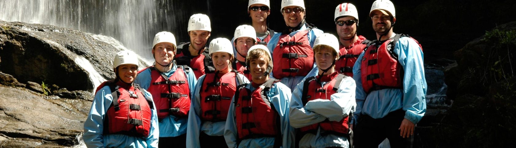 paddlers wearing helmets, life jackets, and wetsuits