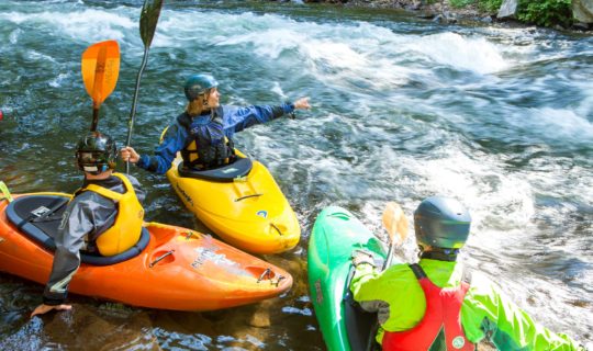 NOC guests kayaking a river in paddling school
