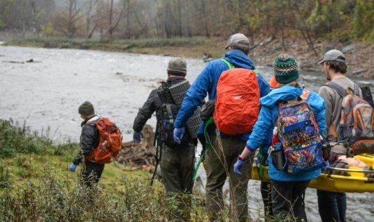 Adults walking towards a river while on the Wilderness Medicine (SOLO Southeast) course