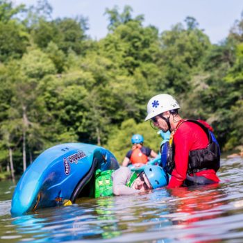 Instructor teaching a child how to roll a kayak during Youth a Summer Day Camps course