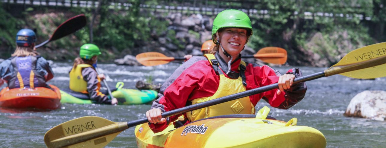 Woman whitewater kayaking with NOC