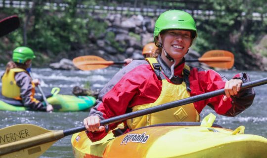 Woman whitewater kayaking with NOC