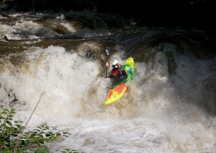kayak going down river cascade