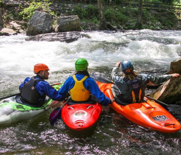 Three kayakers scouting river