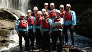 paddlers wearing helmets, life jackets, and wetsuits