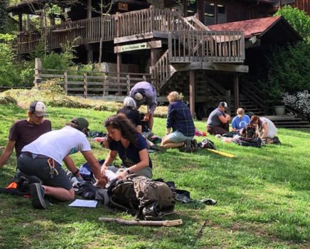 Students practicing wilderness healthcare too people in stretchers