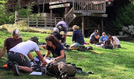 Students practicing wilderness healthcare too people in stretchers