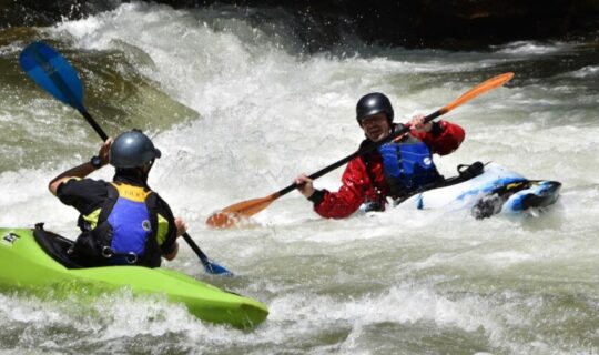 2 kayakers in Class III rapids