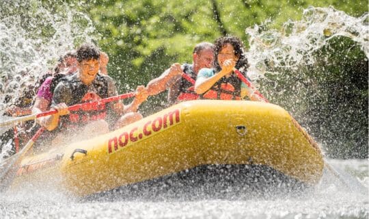 family whitewater rafting on a splashy river