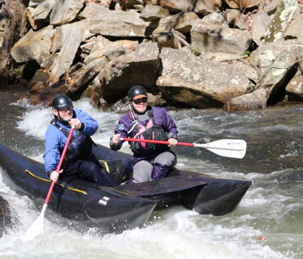 two rafters in a black inflatable pack raft