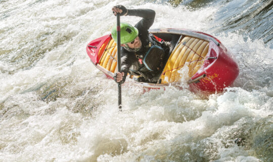 This image shows Instructor William Dupree hitting some epic whitewater rafting waves while in a canoe.
