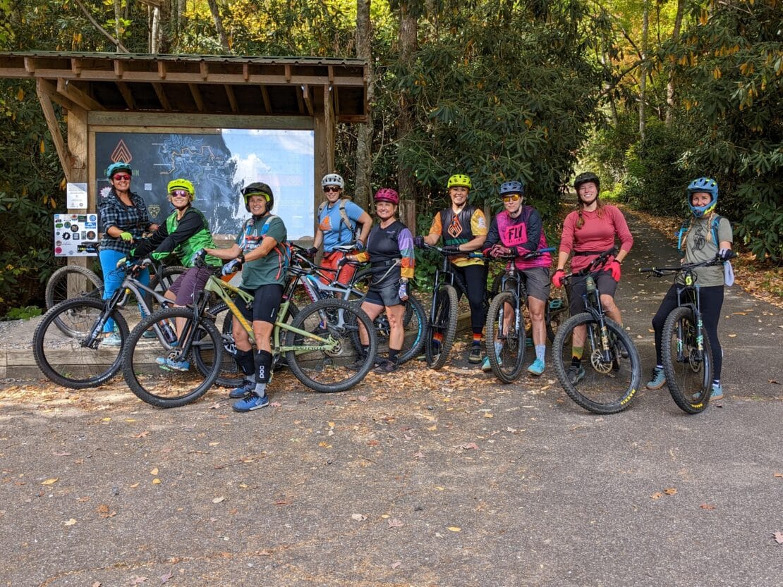 Women in a group posing for a picture with their mountain bikes for women's pedal fest at Nantahala Outdoor Center.