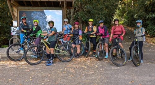 Women in a group posing for a picture with their mountain bikes for women's pedal fest at Nantahala Outdoor Center.