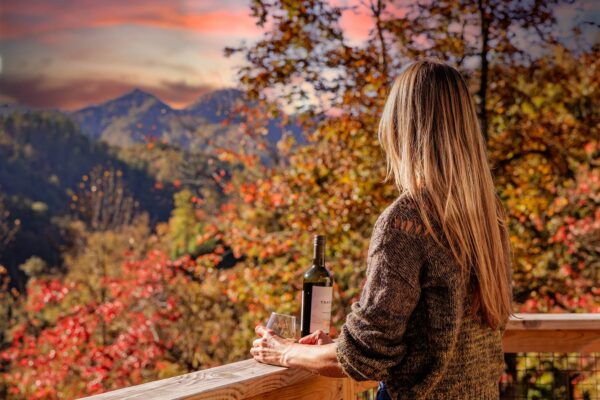 A guest on the porch at The Hemlocks Bungalows enjoying a sunset