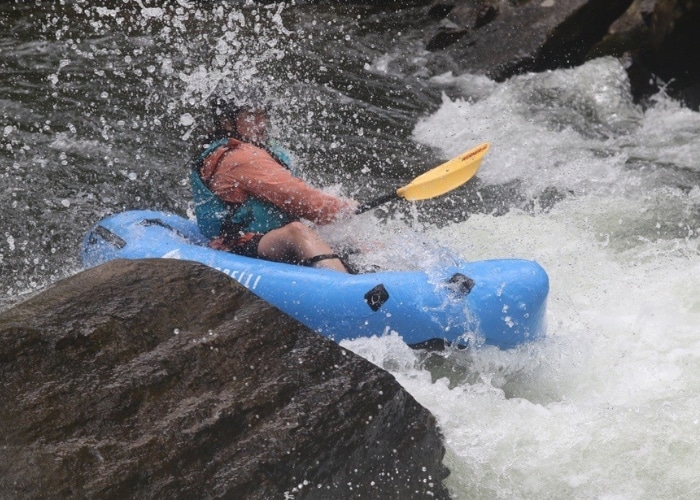 A person going down a small rapid in a packraft.