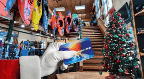 Santa arm holding a Nantahala Outdoor Center Gift Card