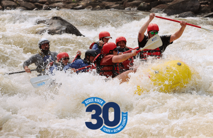 Group rafting through whitewater rapids on the Ocoee River with a guide leading the raft