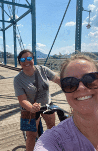 Two friends on bikes crossing the pedestrian bridge in Chattanooga TN